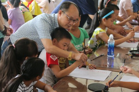 武汉市经济技术开发区(汉南区)卓越书画院曹雕院长在指导孩子们学书法