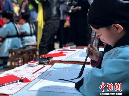 4月2日，“习礼尚贤·明德笃行”——丁酉年学童启蒙开笔礼仪式在孔子出生地夫子洞前广场举行。图为，学童描红学写“人”字。　李欣 摄